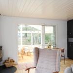 Room with fireplace, dining area, and kitchen. Passage to terrace with seating.