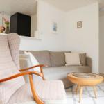 A living room with a chair, a sofa, and a round table.