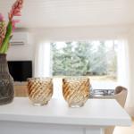 On the countertop are vases with flowers and two glasses.