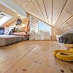 Attic room with wooden floor, window, and toys.