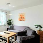 Wohnzimmer mit Sofa, Tisch und Wandbildern.