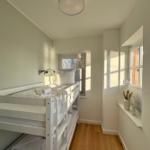 Zimmer mit Doppelstockbett, Holzboden und Fenstern mit Blick.