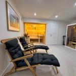 Zwei Liegestühle vor Sauna und Dampfbad im Raum.