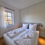 Schlafzimmer mit Doppelbett, Fenster und Holzboden.