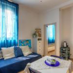 Room with blue curtains, bed, and table with chairs.