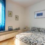 Bedroom with bed, blue curtains, and wall pictures.
