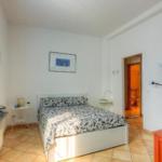 Bedroom with bed, window, and door to bathroom.