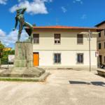 House with orange door and statue in foreground.
