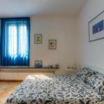 Bedroom with bed, blue curtains, and wall pictures.