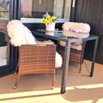 Sie sitzen auf einem überdachten Balkon (Loggia)