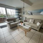 Wohnzimmer mit zwei Sofas, Glas-Tisch und Balkonansicht.