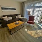 Das Wohnzimmer mit einem gemütlichen Sofa, einem Sessel und einem Couchtisch