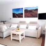 Wohnzimmer mit Sofa, Couchtisch und Wandbildern