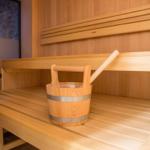 Sauna mit Holzbank und Eimer mit Löffel