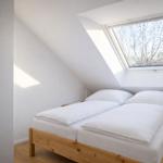 Schlafzimmer mit Dachschrägen, Doppelbett und Dachfenster.