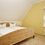 Schlafzimmer mit Holzbett, Fenster und Heizkörper