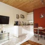 Küche mit Esstisch, Fernseher und Holzdecke.