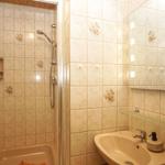 Badezimmer mit Dusche, Waschbecken und Spiegel