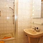 Badezimmer mit Dusche, Waschbecken und Spiegel.