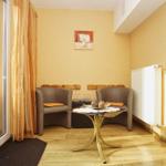 Zimmer mit zwei Sesseln, Tisch und Fenster zur Terrasse.