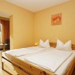 Schlafzimmer mit Doppelbett, Holzmöbel und Terrassentür.