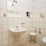 Badezimmer mit Waschbecken, Spiegel, Toilette und Dusche