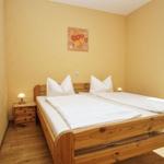 Schlafzimmer mit Holzbett, Nachttisch und Wandbild.