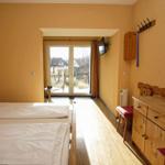 Zimmer mit Doppelbett, Holzmöbel und Balkonansicht