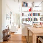 Essbereich mit Holztisch und Bücherregal im Hintergrund.