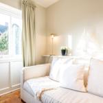 Ein Wohnzimmer mit Sofa, Fenster und Dekoration.