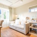 Wohn- und Essbereich mit Sofa, Tisch und Fenster.