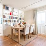Essbereich mit Tisch, Stühlen und Bücherregal. Durchgang zur Schlafzimmerseite.
