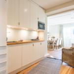 Küche mit Holzoberfläche und Mikrowelle. Blick in Esszimmer mit Tisch und Stühlen.