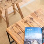 Holztisch mit Magazin und Hocker auf Teppichboden