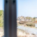 Ansicht durch Fenster auf Dörfer mit Strohdächern und Straße