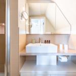 Bad mit Dusche, Waschbecken und Spiegel