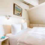 Schlafzimmer mit Doppelbett, Nachttisch und Wandbild