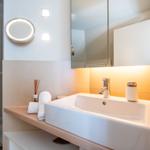 Bad mit Dusche, Waschbecken und Spiegel