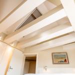 Schlafzimmer mit weißen Balken an der Decke und einem Bild an der Wand.