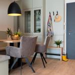 Essbereich mit Tisch, Stühlen und Beistellbank. Hintergrund: Schrank und Tür.