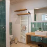 Badezimmer mit Dusche, Waschbecken und Heizkörper