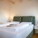 Schlafzimmer mit Bett, Nachttisch und Holzdecke.