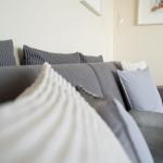 Grauer Sofa mit Kissen und Wandbildern