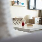 Wohnzimmer mit Couch, Fernseher und Tisch mit Blume.