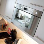 Küche mit Dunstabzugshaube, Kochfeld und Küchenzeile