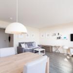 Wohn- und Essbereich mit Sofa, Fernseher und Esstisch.