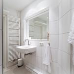 Badezimmer mit Spiegel, Waschbecken und Handtuch