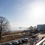 Blick auf Strand, Promenade und Hotel mit Steg.