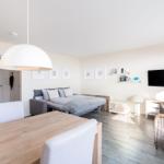 Wohn- und Essbereich mit Bett, TV und Esstisch