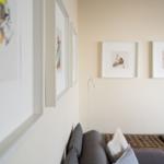 Wohnbereich mit Sofa, Korbhocker und Wandbildern.